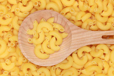 Group of pasta noodles on a wooden spoon forming a backgroundの写真素材