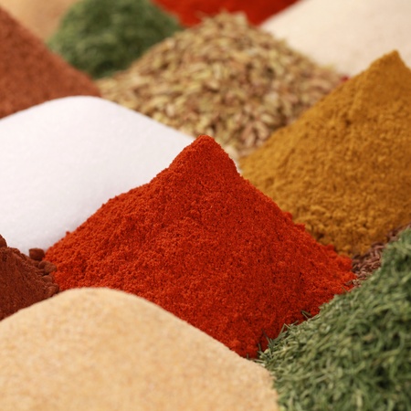 Colorful spices and herbs like paprika powder, curry powder and caraway on a bazaarの写真素材