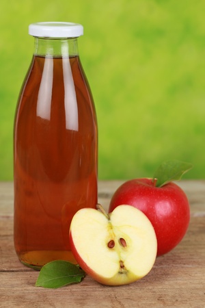 Apple juice in a bottle decorated with ripe applesの写真素材