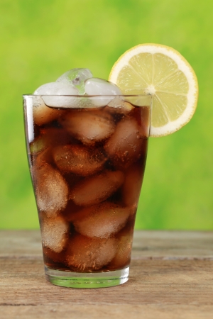 Cold Cola in a glass with ice cubes, served with a lemonの写真素材