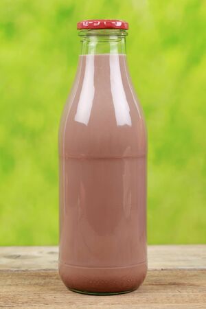 Fresh chocolate drink in a bottle with a green backgroundの写真素材