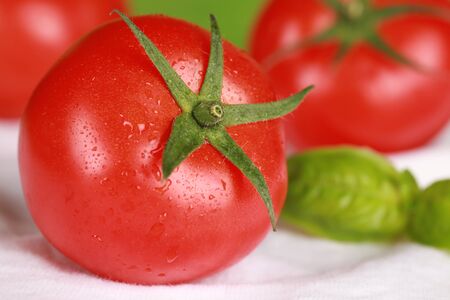 Macro shot of a fresh tomato decorated with basil and plenty of copy spaceの写真素材