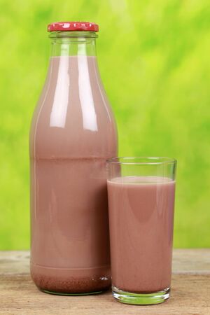 Chocolate milk in a bottle and in a glass on a wooden tableの写真素材