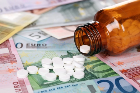 Symbolic picture for high cost of medicine with pills on moneyの写真素材