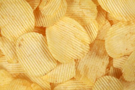 Collection of rippled potato chips forming a backgroundの写真素材