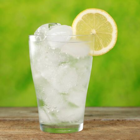 Glass with water and ice cubes, served with a lemonの写真素材