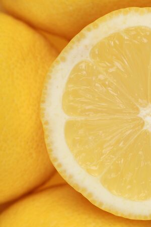 Closeup of a sliced lemon, served with more lemonsの写真素材