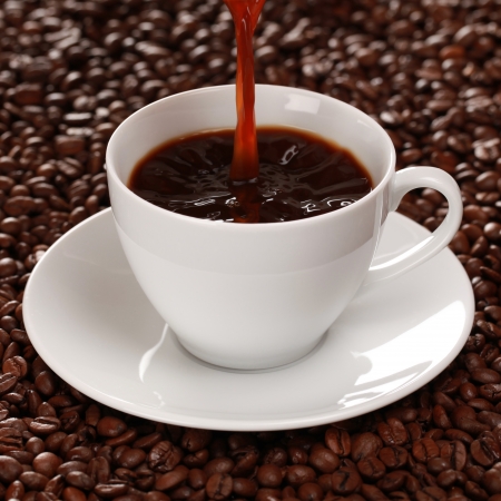 Hot coffee is pouring into a coffee cupの写真素材