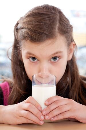 Healthy eating: Young girl drinking milk from a glassの写真素材