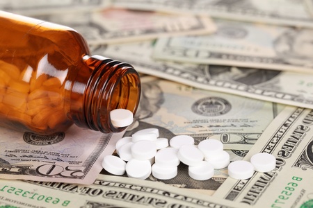 Symbolic picture for high cost of medicine with pills on money (Dollar)の写真素材