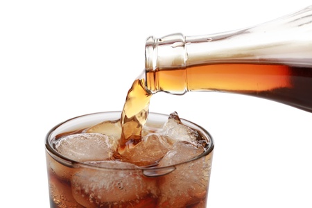 Cola is pouring from a bottle into a glassの写真素材
