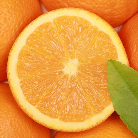 Macro shot of a sliced fresh orange with a leafの写真素材