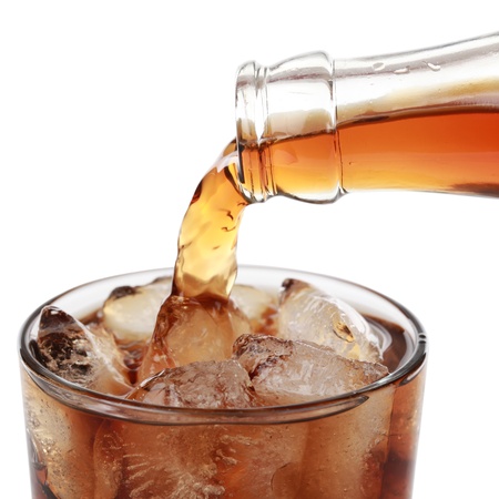 Cola is pouring from a bottle into a glass, isolated on white Cola is pouring from a bottle into a glass, isolated on white