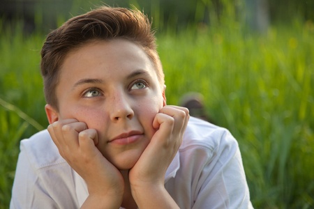Portrait of a young boy day dreaming in natureの写真素材
