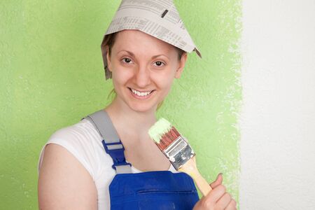 Young woman painting a wall with a paintbrushの写真素材