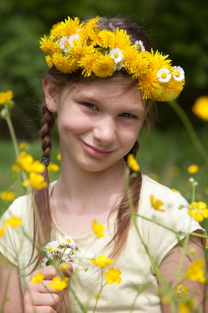 Little girl with flowers on her head in natureの写真素材