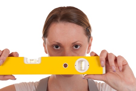 Young carpenter holding a spirit level in her hand, isolated on whiteの写真素材