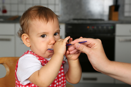 Little baby girl is hungry, mother feeding herの写真素材