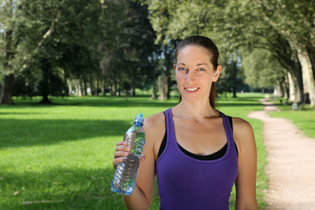 Athletic young woman with a water bottle during sports or runningの写真素材