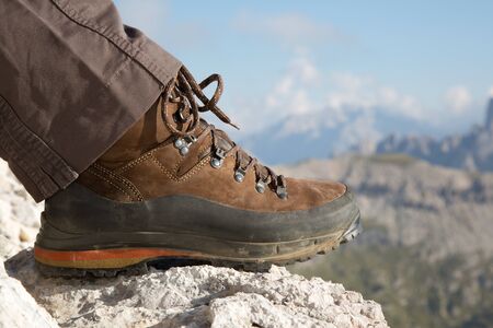 Hiking boots of a hiker on a rock in the mountainsの写真素材
