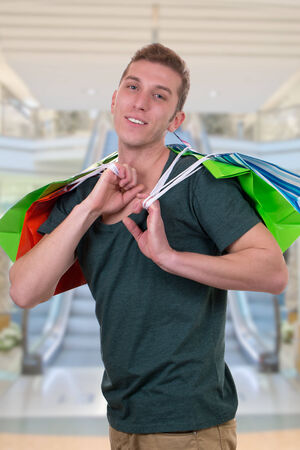 A young man with shopping bags standing in a shopping mall
の写真素材