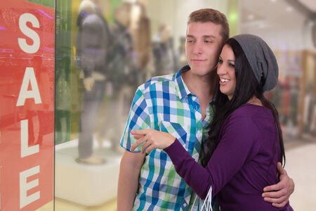 A young couple doing window shopping in a mallの写真素材