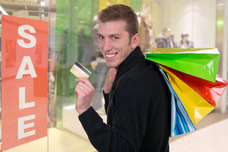 Smiling man with credit card and shopping bags in a shop
の写真素材
