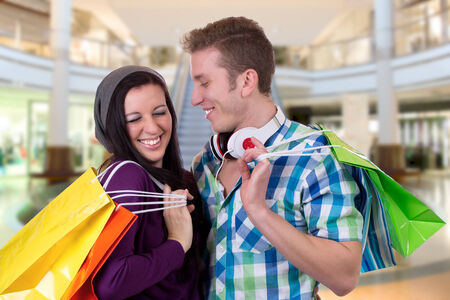 A young couple having fun while shopping in a shopping mallの写真素材