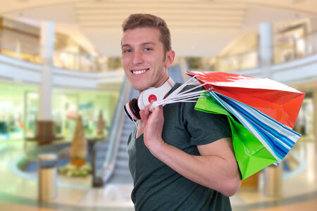 Casual young man with shopping bags in a shopping mallの写真素材