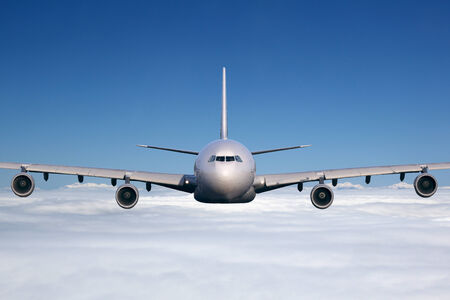 An airplane is flying in the sky over the cloudsの写真素材