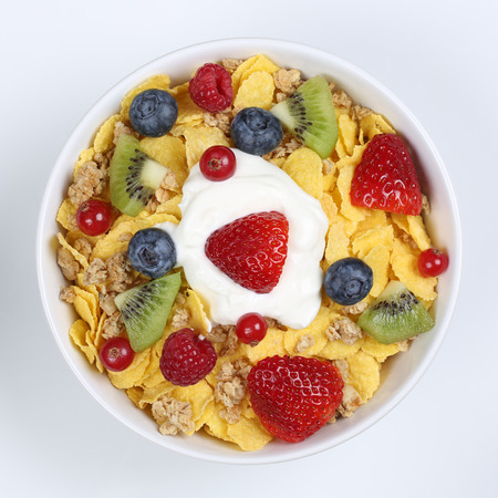 Fruit cereals with yogurt, strawberries, banana, raspberries, kiwi and blueberries in a bowl from aboveの写真素材