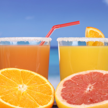 Orange juice or cocktail from oranges on the beach at the seaの写真素材