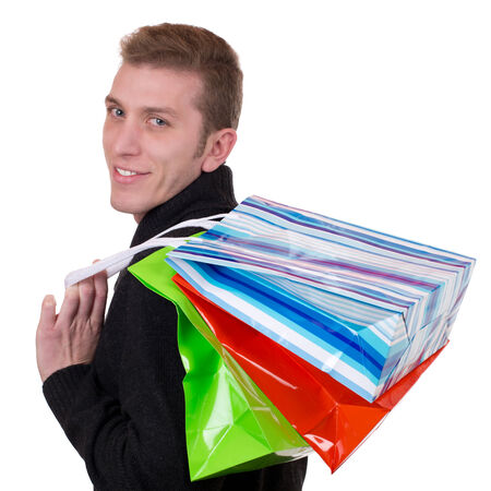 Smiling young man with shopping bags, isolated on whiteの写真素材