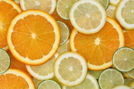 Background made from sliced orange, lemon and lime citrus fruitsの写真素材