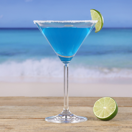 Blue Curacao cocktail drink on the beach and seaの写真素材