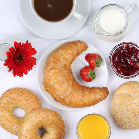 Set table with breakfast, bagels, marmalade, coffee and orange juice from aboveの写真素材