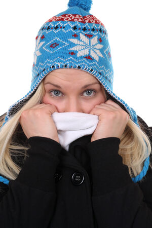 Young woman with a cap freezing in winter, isolated on a white backgroundの写真素材