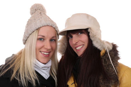 Two smiling women in winter with scarf and caps, isolated on a white backgroundの写真素材
