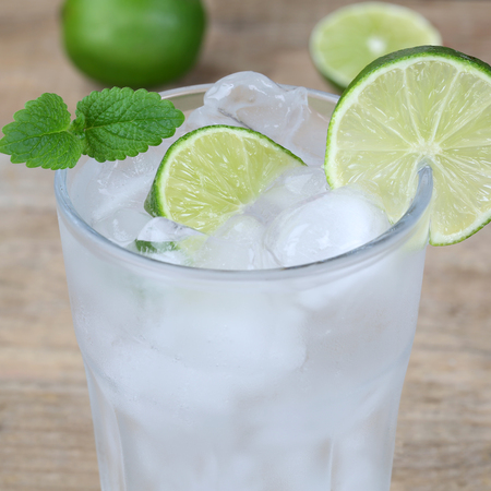 Cold sparkling water drink with ice cubes and limesの写真素材