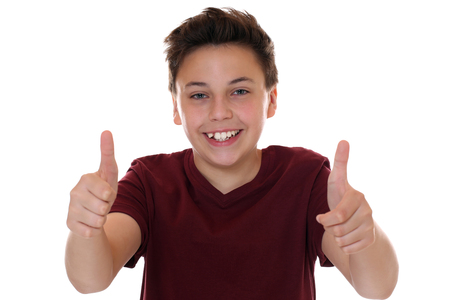 Smiling young teenager boy showing thumbs up, isolated on a white backgroundの写真素材