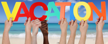 Hands holding the word vacation on beach, sand and seaの写真素材