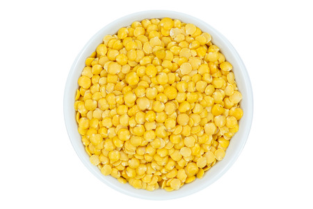 Yellow lentils raw from above bowl isolated on a white background