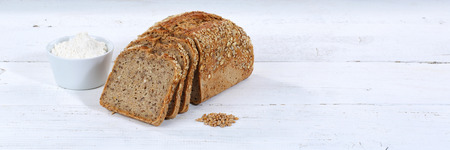 Whole wheat grain bread slice slices sliced loaf banner copyspace on wooden board wood