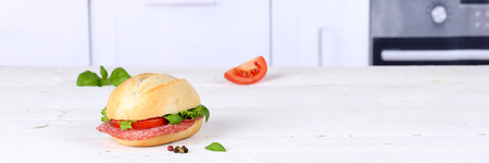 Sandwich baguette with salami ham copyspace banner on wooden board wood