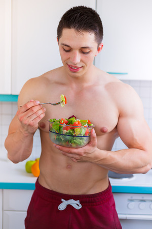 Young man eating salad bodybuilder bodybuilding healthy eat portrait format vegan vegetarianの写真素材