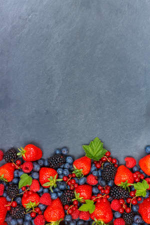 Berries fruits berry fruit strawberries strawberry blueberries blueberry with copyspace copy space portrait format on a slate summerの写真素材