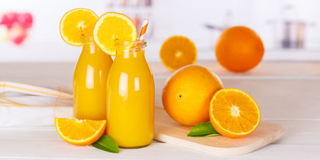 Orange juice drink in bottle on wooden board panorama orangesの写真素材