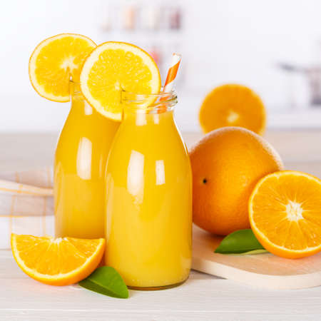 Orange juice drink in bottle on wooden board square orangesの写真素材