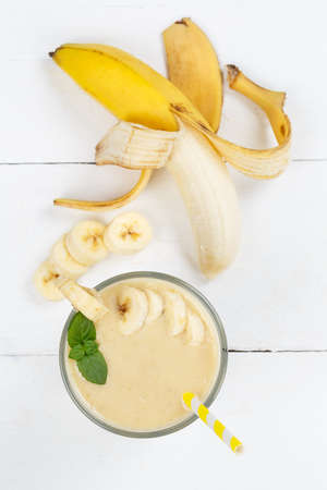 Banana fruit juice smoothie fresh drink in a glass from above portrait format healthy drinkingの写真素材