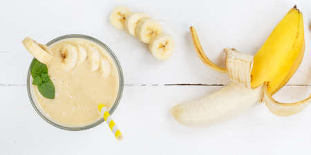 Banana fruit juice smoothie fresh drink in a glass from above panorama healthy drinkingの写真素材